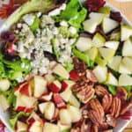overhead view of a fall salad with cut up apples, pears, pecans, and blue cheese