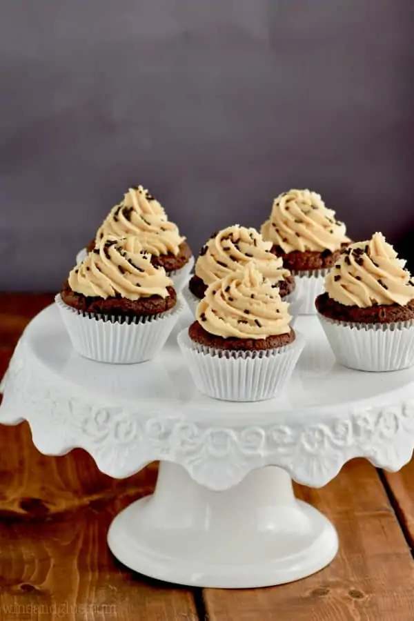 In white cupcake liners, are the Chocolate Peanut Butter Brownie Cupcakes topped with Peanut Butter frosting in a whipped shaped and chocolate sprinkles. 