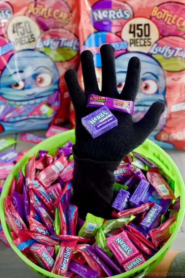 The Scary Halloween Treat Bucket has a hand coming out and filled with candy 