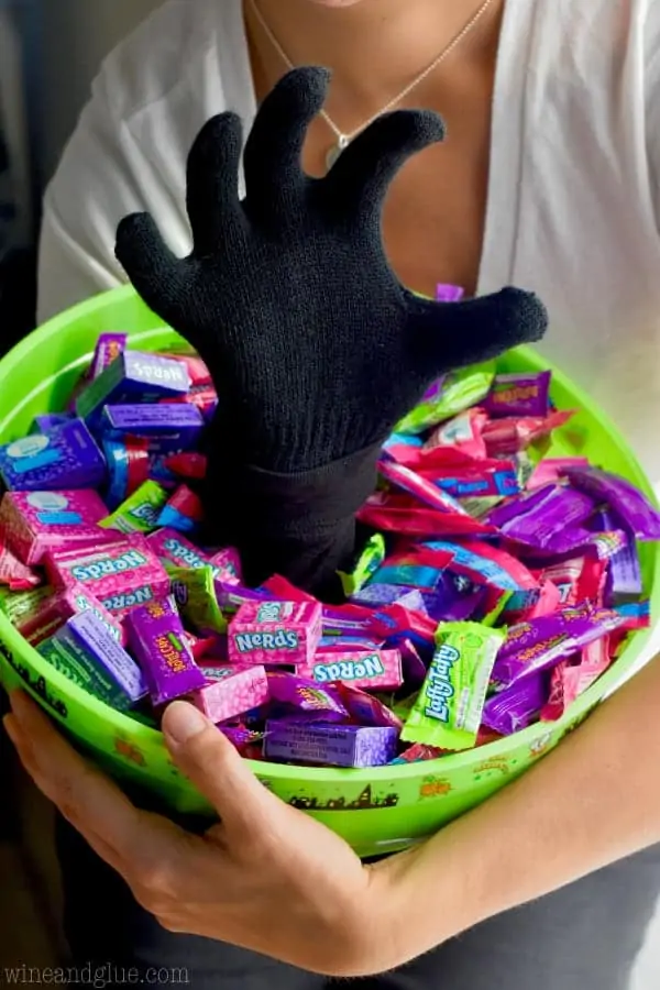 The Scary Halloween Treat Bucket with a hand coming out in a claw shape filled with candy. 