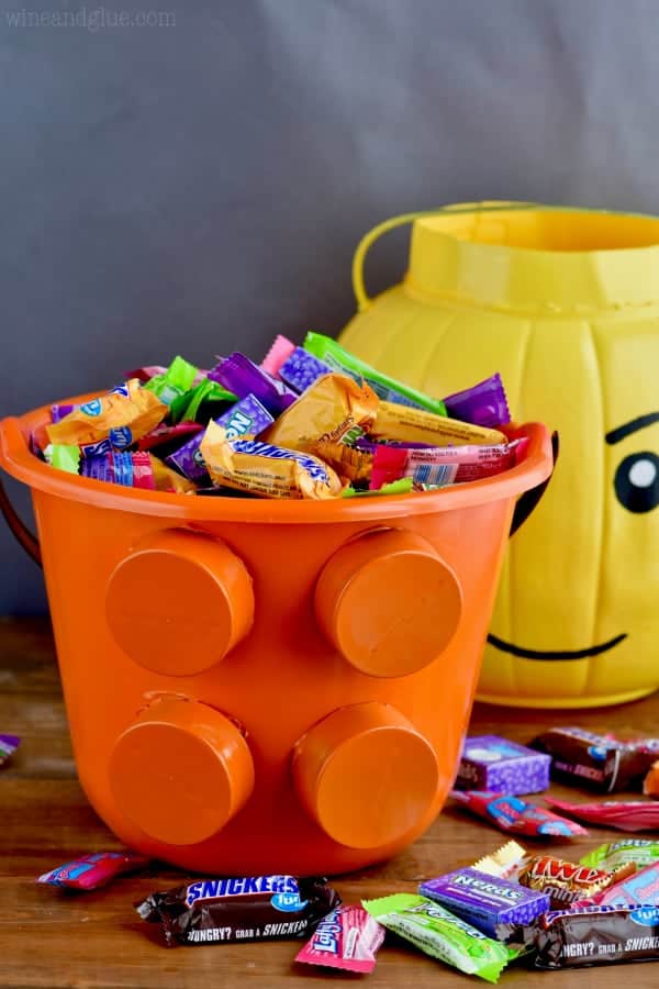In the foreground, the lego piece bucket is filled with candy. 