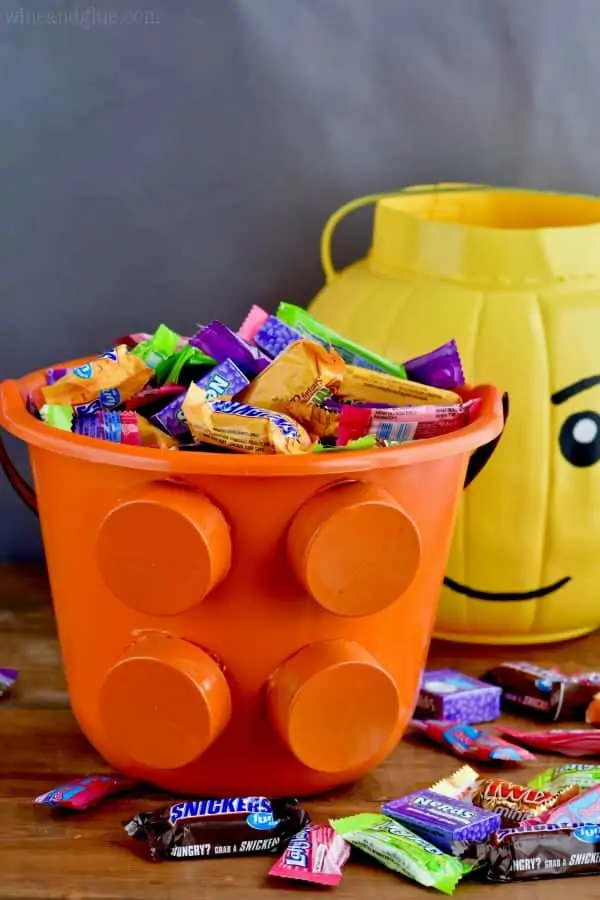 In the foreground, the lego piece bucket is filled with candy. 