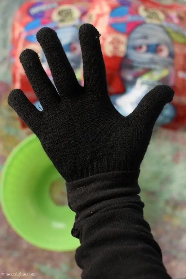 With the black glove attached to the sleeve, you wear the whole thing and place your hand through the whole into the bucket. 