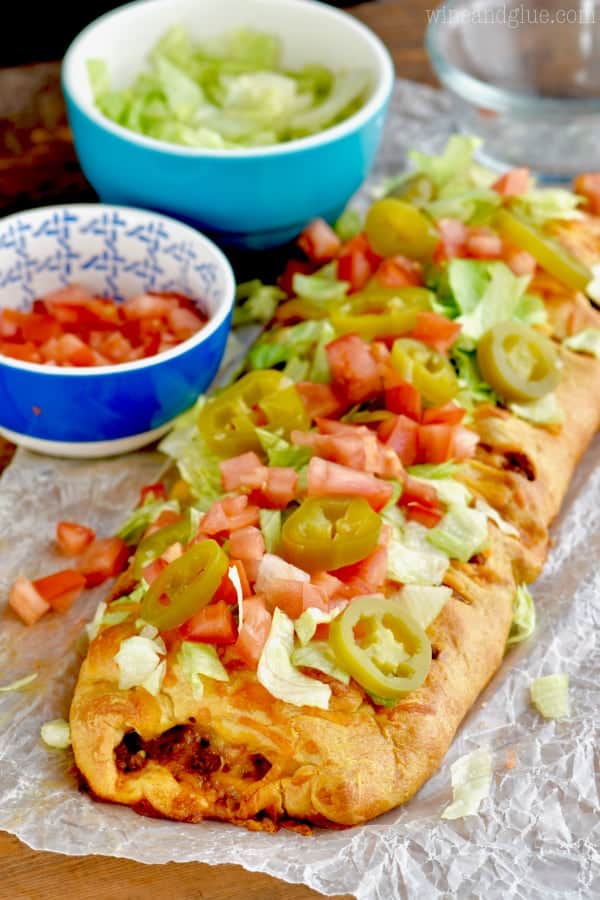 taco braid made from crescent dough, topped with fresh tomatoes, lettuce, and jalapeños