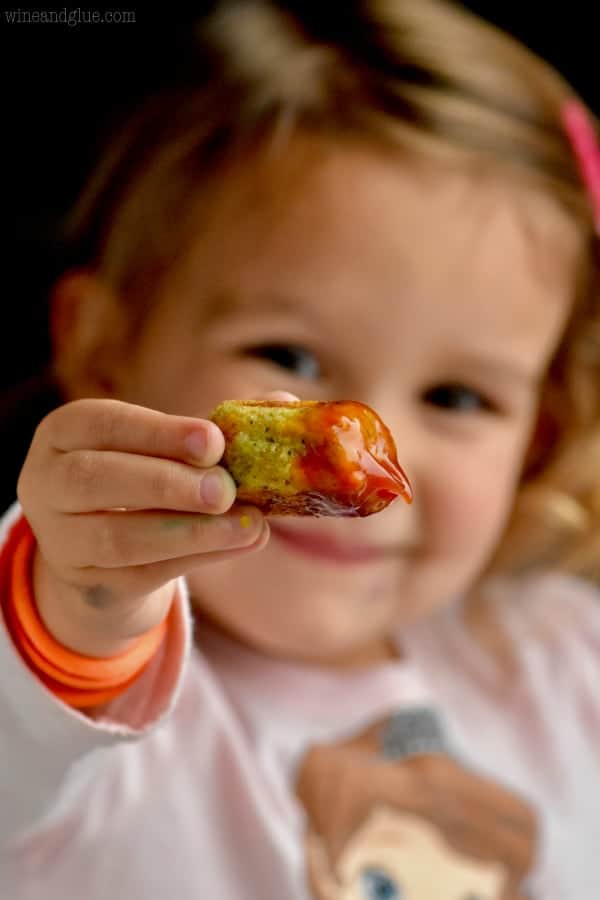 little girl holding a broccoli tator tot