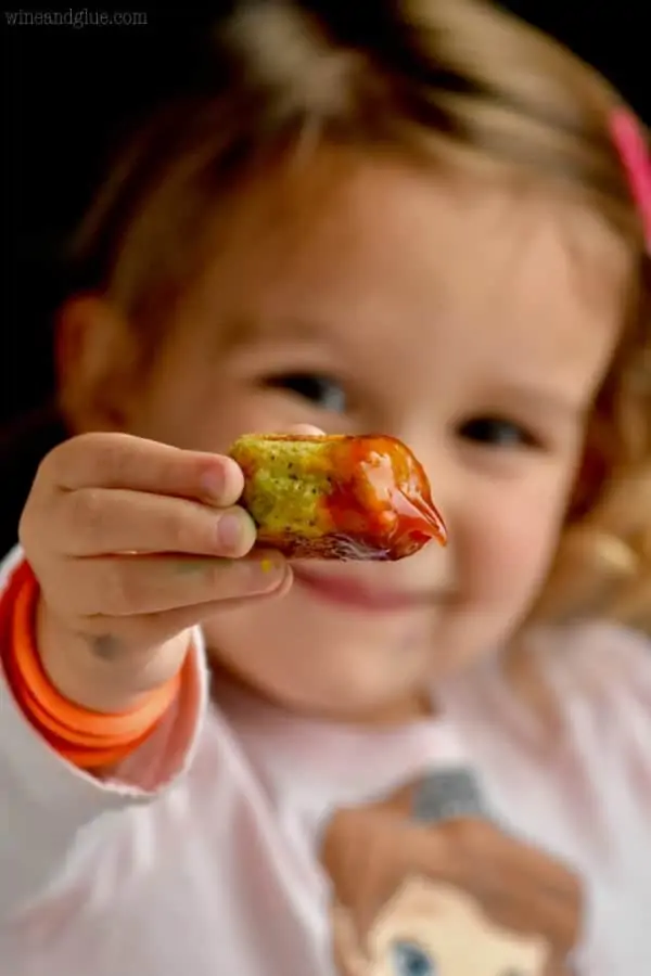 little girl holding a broccoli tator tot
