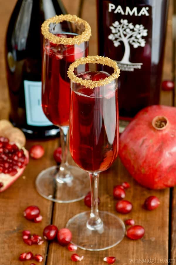 In a champagne fluke, the Cranberry Pomegranate Champagne Cocktails has little bits of cranberry and pomegranate and around the rim is gold sprinkles. 