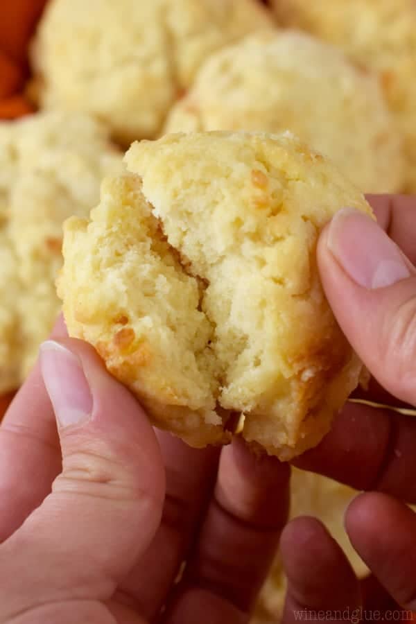 A woman is breaking apart the Fast Easy Biscuit that shows a soft and fluffy interior with a golden brown exterior. 