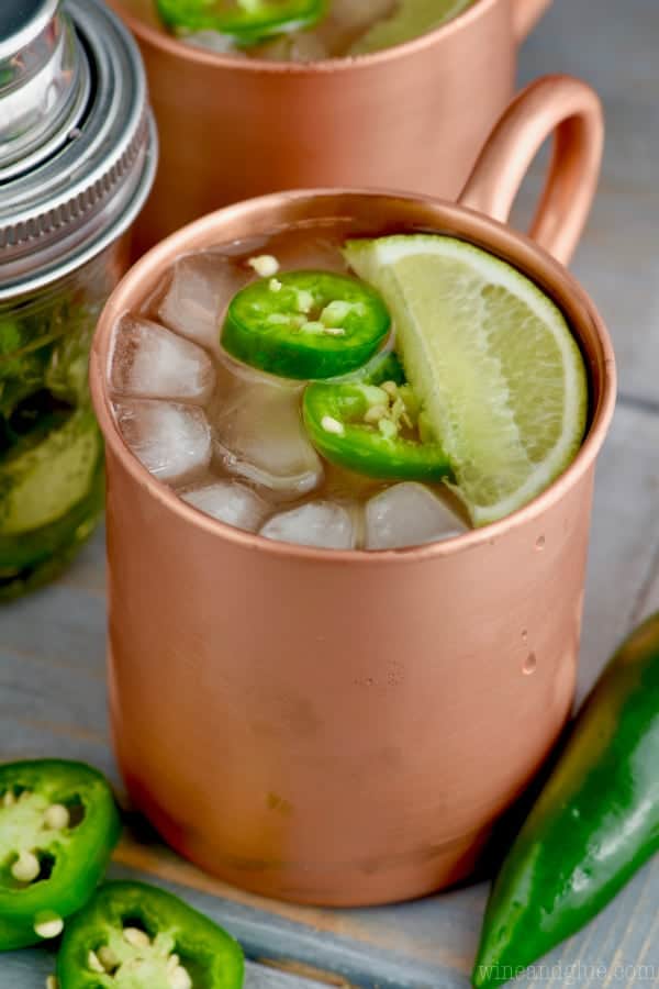 The Jalapeño Moscow mule are in copper mugs with ice, chopped Jalapeño, and a lime slice. 