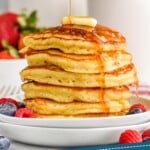 pinterest graphic of stack of buttermilk pancakes with syrup being drizzled over them