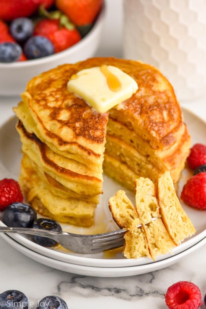 overhead stack of best buttermilk pancakes sliced with a bite on a fork