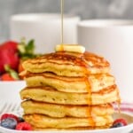 stack of buttermilk pancakes with syrup being drizzled over them