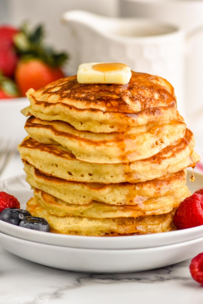 stack of buttermilk pancakes that have had syrup poured on them