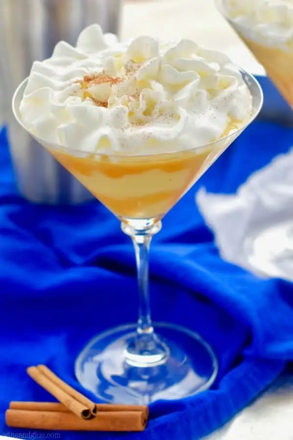 A glass of the Eggnog Martini with whip cream on top and caramel dripping on the sides. 