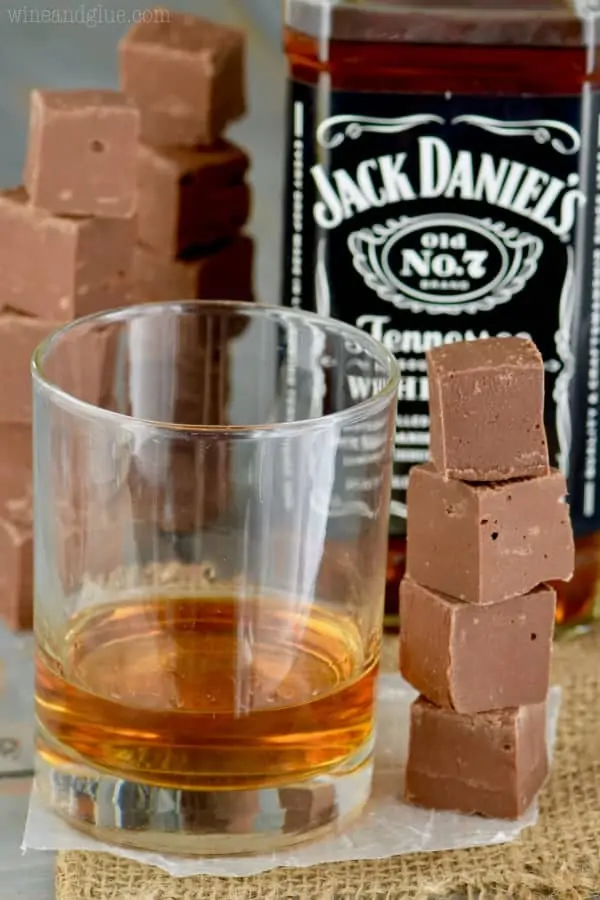 Next to a glass of whiskey is a tower of cubed Jack Daniel's Fudge