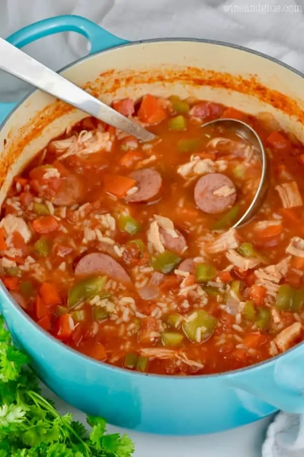 In a blue pot, the Jambalaya Soup is a beautiful dark red color showing the different components of the soup. 