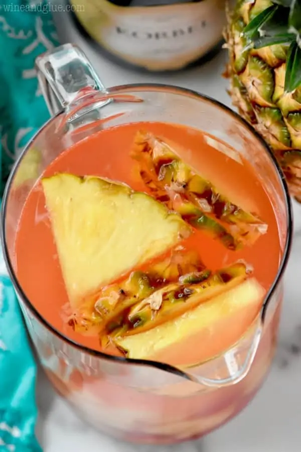 An overhead photo of a pitcher of the Pina Colada Rum Punch with sliced pineapple floating. 