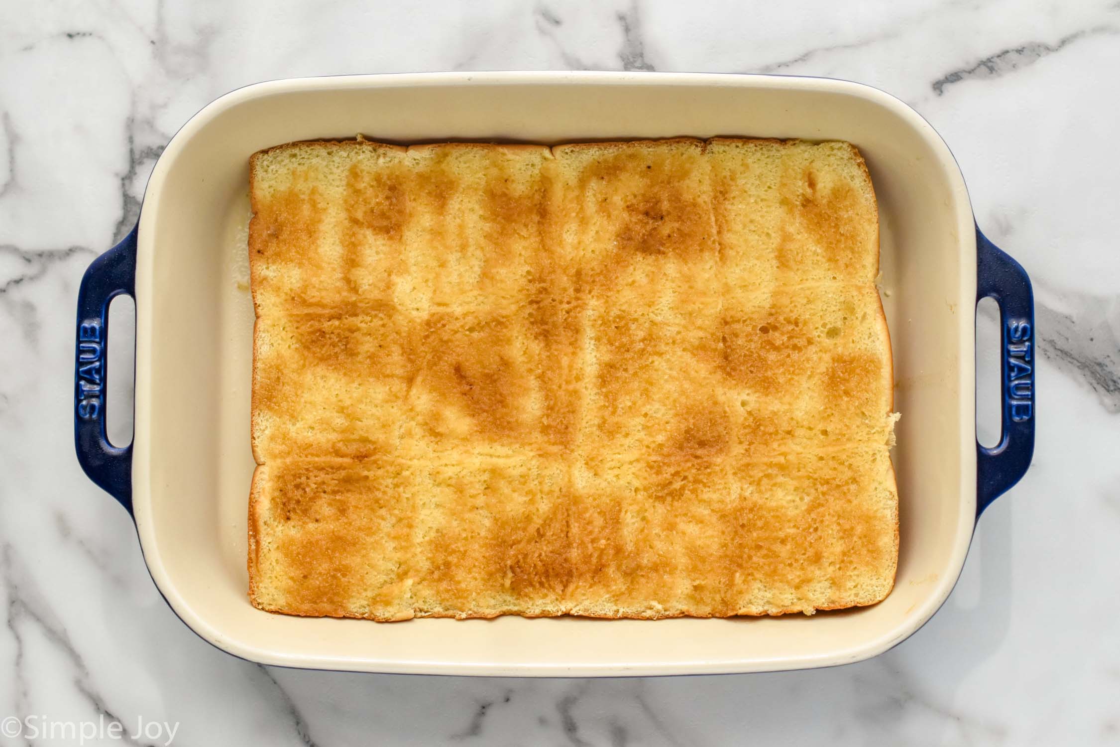 Overhead photo of a baking dish with rolls for Philly Cheesesteak Sliders recipe.