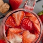 overhead of a pitcher of rose sangria filled with strawberries