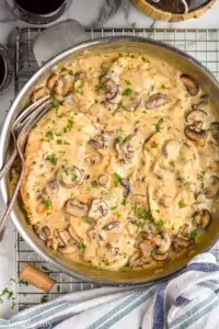 overhead view of a pan full of chicken marsala garnished with parsley