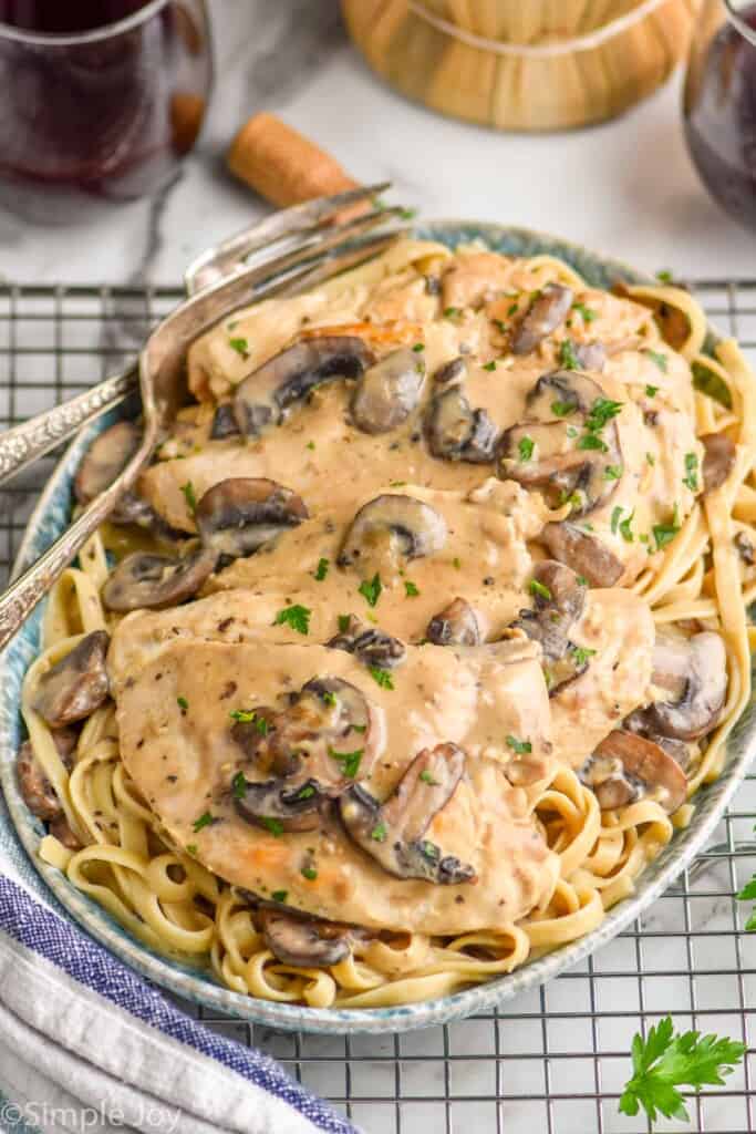 a platter of easy chicken marsala on a bed of fettuccine noodles