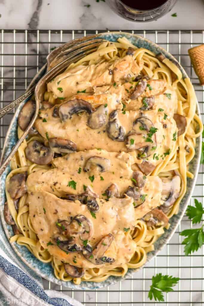 overhead of a platter of easy chicken marsala recipe on a bed of fettuccine noodles