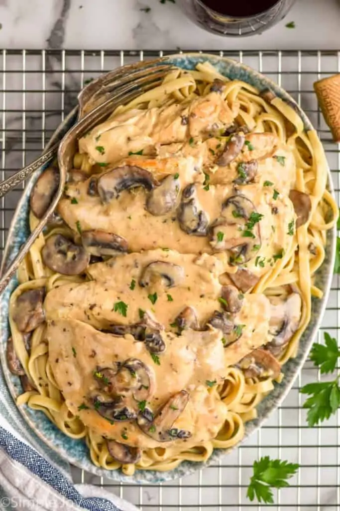 overhead of a platter of easy chicken marsala recipe on a bed of fettuccine noodles