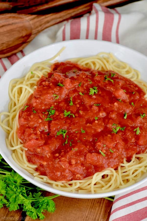 In a white plate is some spaghetti topped with the Easy Homemade Spaghetti sauce and parsley. 
