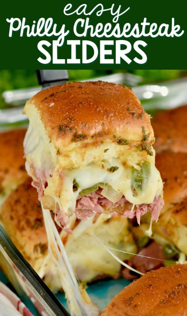 A Philly Cheesesteak Sliders is being lifted out of the casserole dish causing some cheese pull