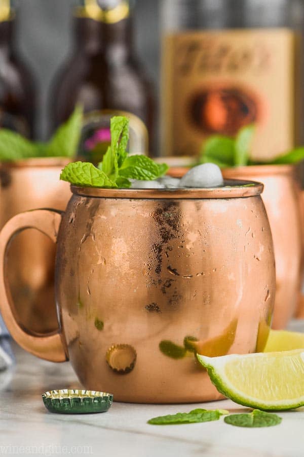 moscow mule in sweaty copper mug garnished with mint and lime