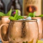 moscow mule in sweaty copper mug garnished with mint and lime