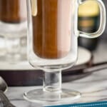 pinterest image showing Irish coffee in Irish coffee mugs with cream dripping down the sides