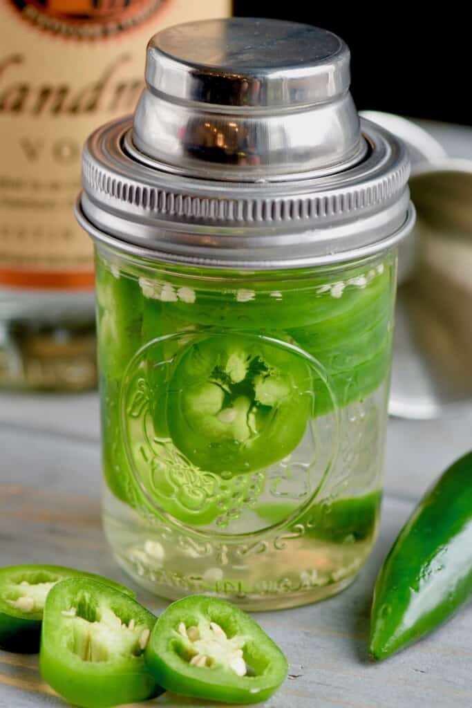 a mason jar full of jalapeno infused vodka