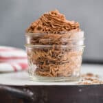 homemade chocolate whipped cream that has been piped into a small mason jar and is sitting on a white tray with chocolate shavings around it - 13