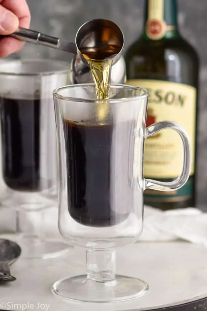 whiskey being poured into a glass of coffee