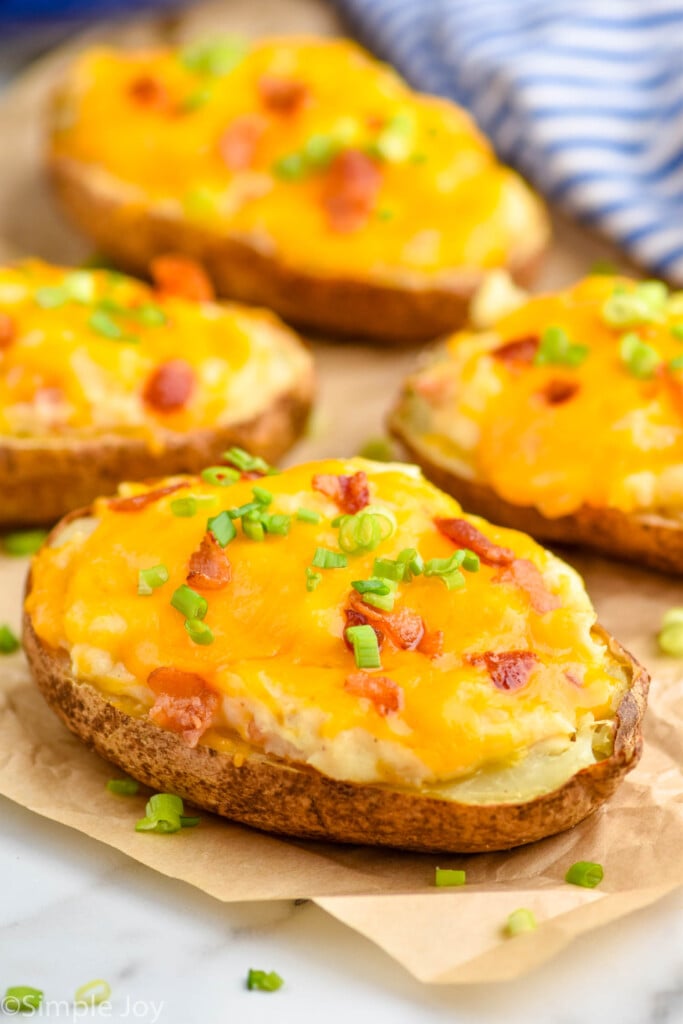 side view of four twice baked potatoes on a piece of parchment paper