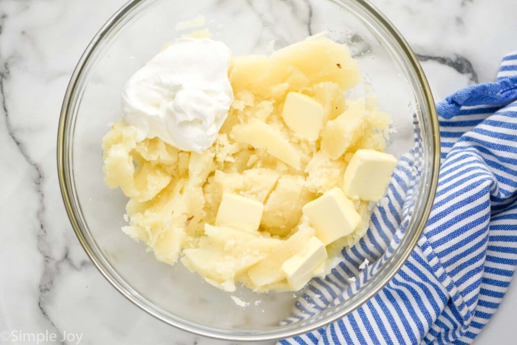 overhead of a bowl with cooked potato sour cream and butter