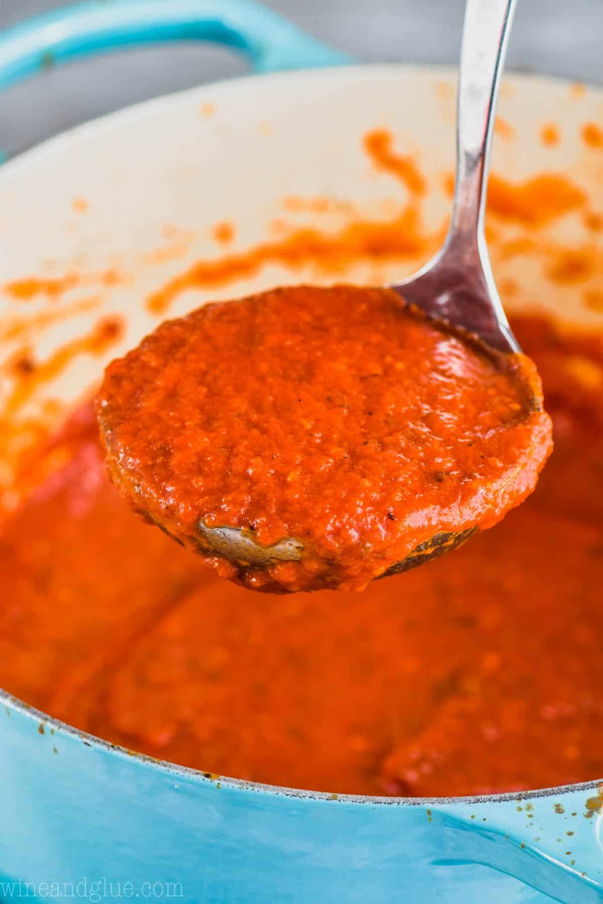 marinara sauce from scratch being ladled out of a dutch oven