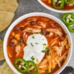 overhead view of a bowl of instant pot taco soup garnished with sour great, shredded cheese, and freshly sliced jalapeños - 11