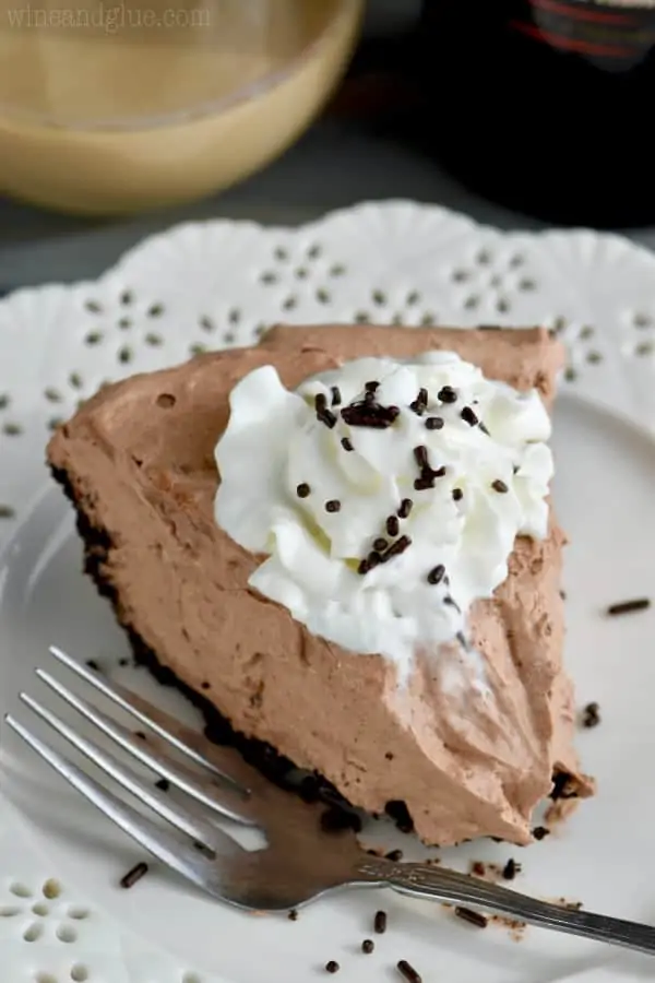 With a small bite, a slice of No Bake Baileys Chocolate Pie has a small dollop of whip cream and chocolate sprinkles. 