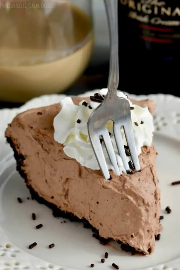 A slice of No Bake Baileys Chocolate Pie with a small dollop of whip cream and chocolate sprinkles. 