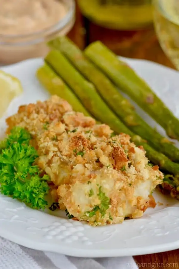 fried fish on a white plate with asparagus