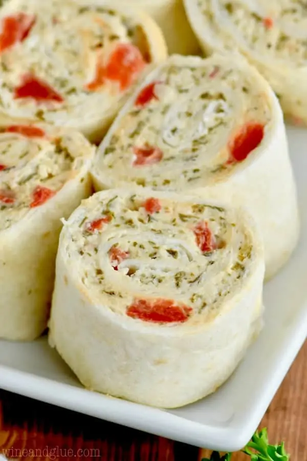 A closeup photo of the Pesto Cream Cheese Pinwheels on a white plate