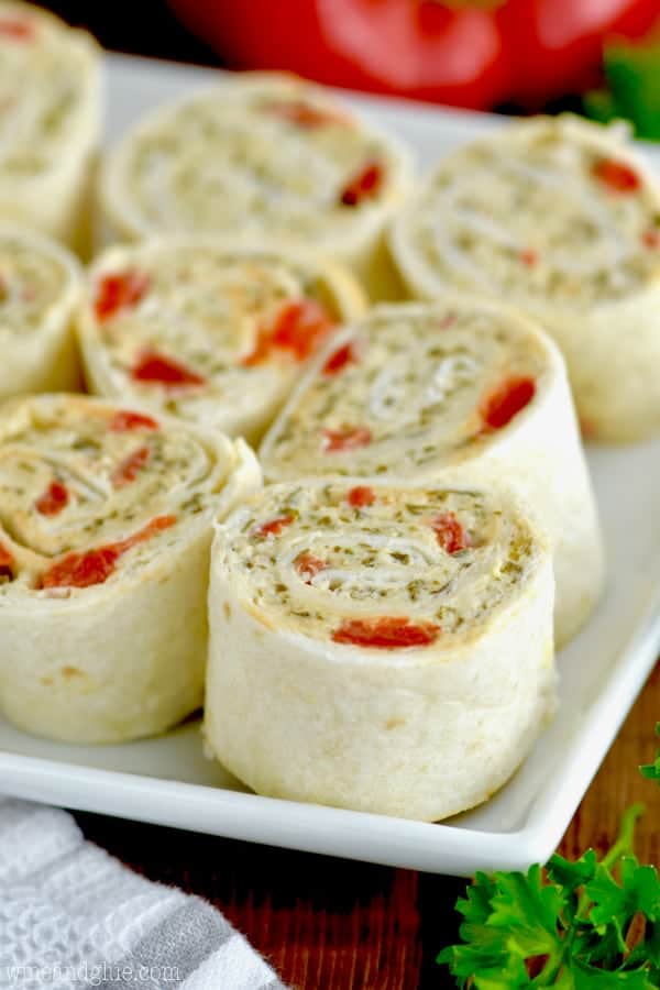 A closeup side photo of the Pesto Cream Cheese Pinwheels that are on a white plate