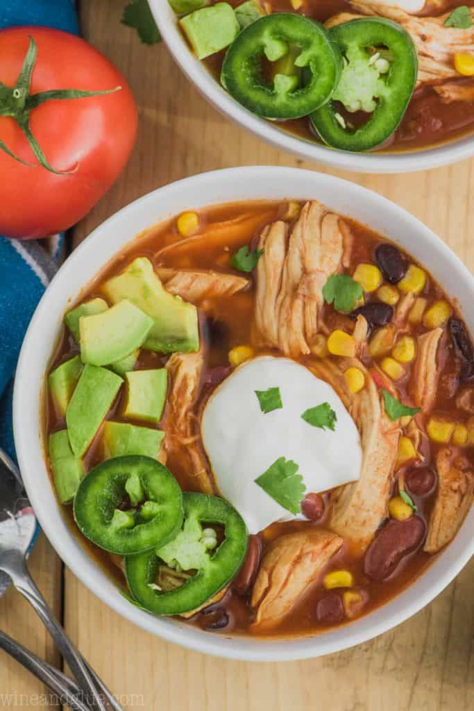 overhead shot of instant pot chicken taco soup recipe in a bowl with sour cream and jalapeños