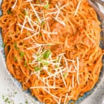 pinterest graphic of overhead view of a platter of creamy spaghetti garnished with freshly grated Parmesan cheese
