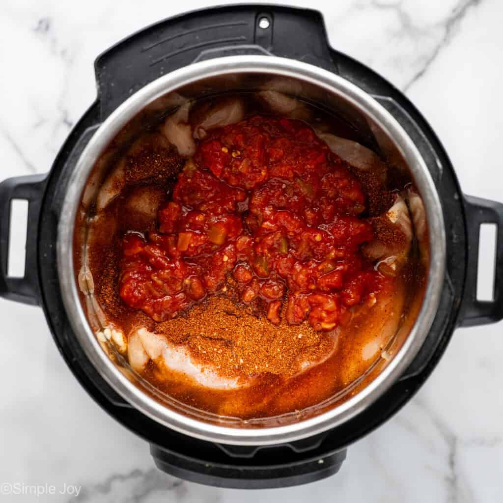 salsa and taco seasoning added to chicken tenders in an instant pot