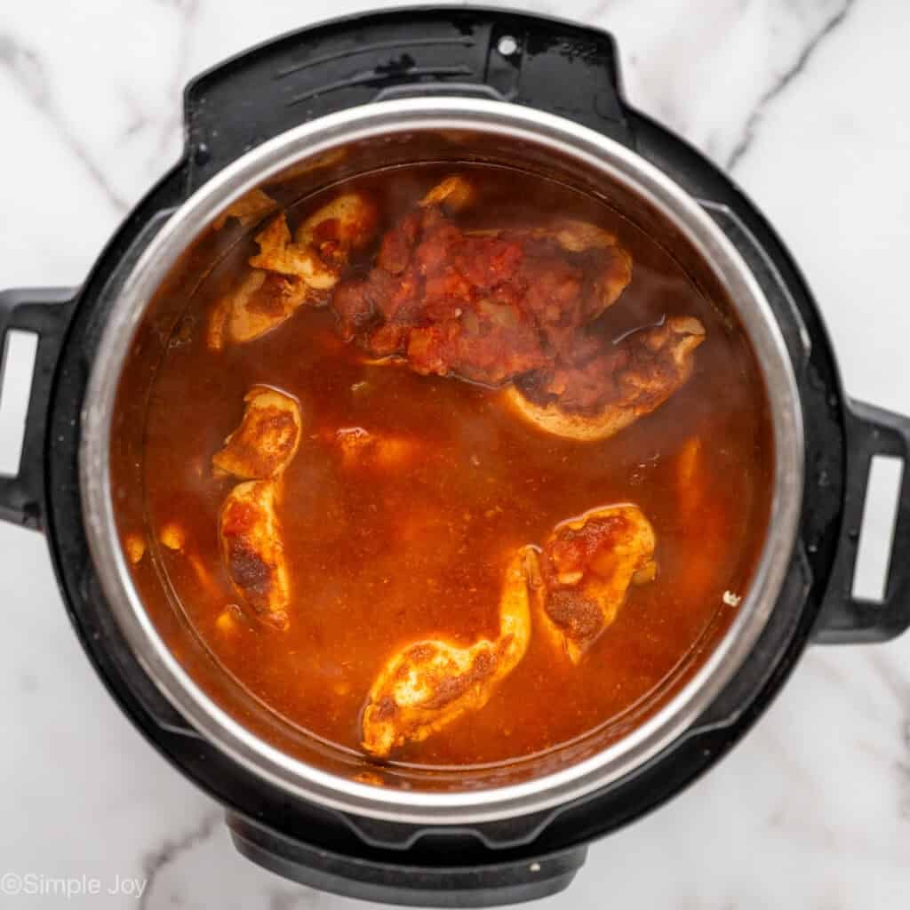 cooked chicken tenders in a salsa and broth mixture inside a pressure cooker