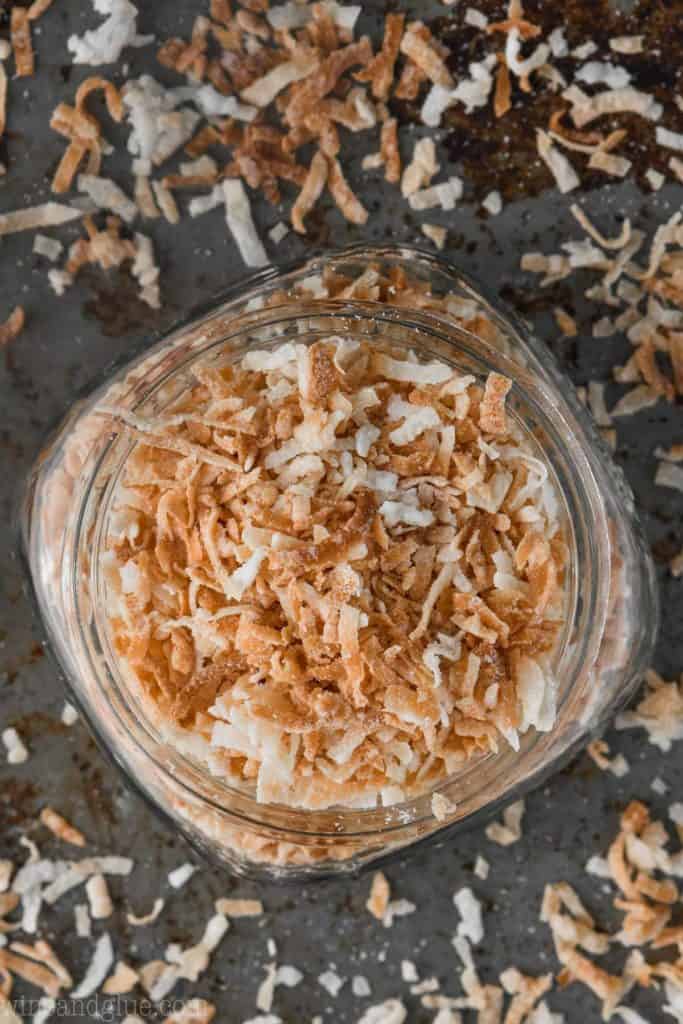 overhead view of mason jar filled with toasted coconut flakes