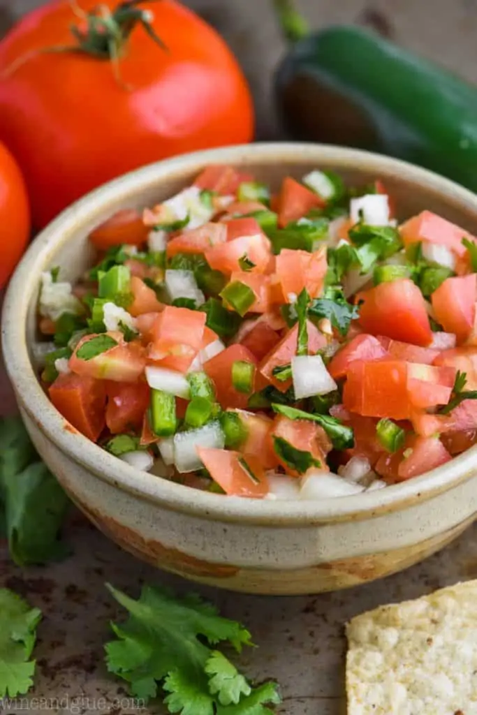 A small bowl of Pico de Gallo garnished with cilantro 